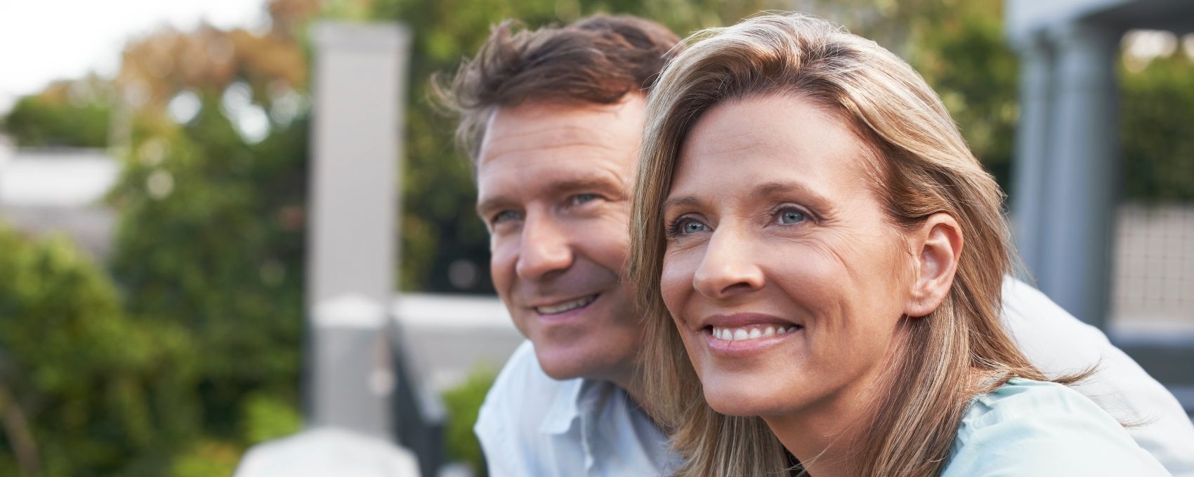 Thoughtful couple looking away while standing in balcony